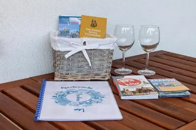 a table with a basket and two glasses of wine at Apartamenty Lea in Kraków