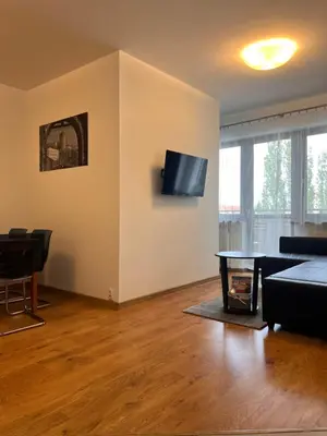 a living room with a couch and a tv on a wall at Apartamenty Lea in Kraków