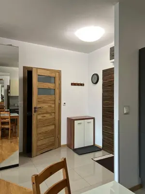 a living room with a door and a table at Apartamenty Lea in Kraków