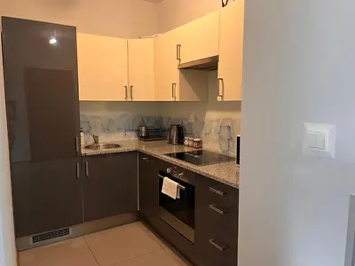 a kitchen with black and white cabinets and appliances at Apartamenty Lea in Kraków