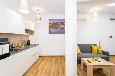 a kitchen and living room with a couch and a table at Apartamenty Bosacka WAWELOFTS in Kraków