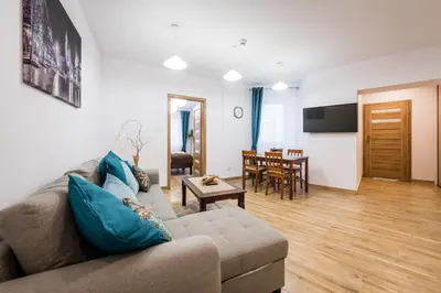 a living room with a couch and a table at Apartamenty Bosacka WAWELOFTS in Kraków