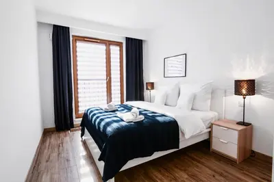 a bedroom with a large bed and a window at Browar Lubicz Residence in Kraków