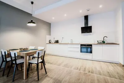 a kitchen and dining room with a table and chairs at Browar Lubicz Residence in Kraków