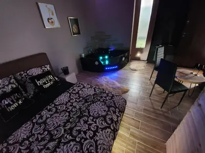 a bedroom with a bed and a fireplace and a table at Apartament z jacuzzi Kraków in Kraków