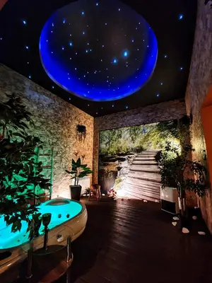 a room with a bath tub and a painting of a universe at Apartament z jacuzzi Kraków in Kraków