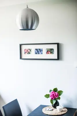 a table with a vase of pink flowers on it at Apartamenty Algador in Kraków