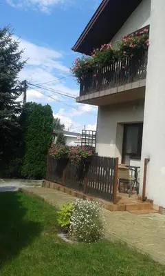 a house with a balcony with flowers on it at Apartamenty Algador in Kraków