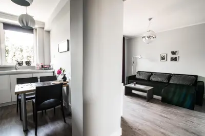 a living room and kitchen with a couch and a table at Apartamenty Algador in Kraków