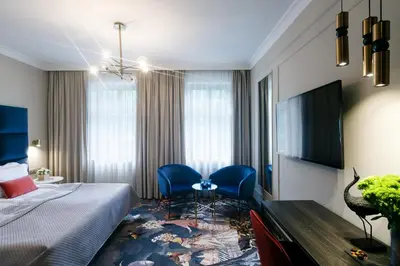 a hotel room with a bed and a table and chairs at Queen Boutique Hotel in Kraków