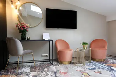 a living room with two chairs and a mirror at Queen Boutique Hotel in Kraków