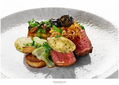 a plate of food with meat and vegetables on it at Queen Boutique Hotel in Kraków