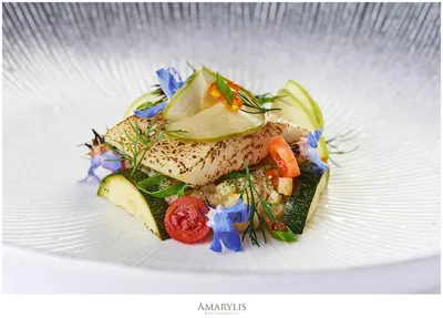 a plate of food with fish and vegetables on it at Queen Boutique Hotel in Kraków