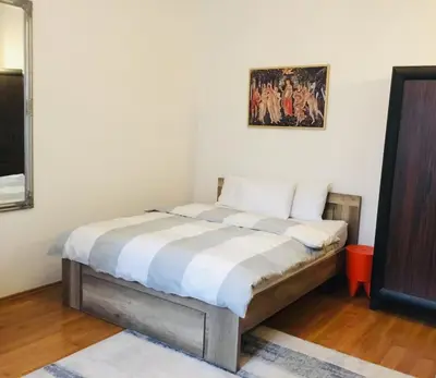 a bed in a room with a painting on the wall at Zamoyskiego in Kraków