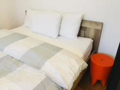 a bedroom with two beds and a orange stool at Zamoyskiego in Kraków