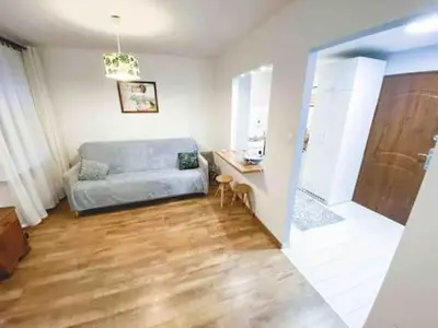a living room with a blue couch and a desk at Comfortable Apartment in Kraków