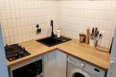 a kitchen counter with a sink and a stove at Comfortable Apartment in Kraków