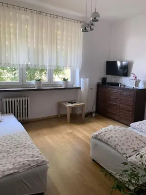 a bedroom with two beds and a flat screen tv at Apartament Aga1 in Oświęcim