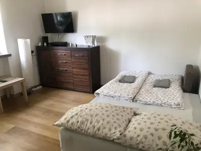 a bedroom with two beds and a tv on a dresser at Apartament Aga1 in Oświęcim
