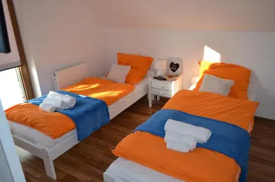 two beds in a room with orange and blue at Pokoje na Wzgórzu in Kasina Wielka