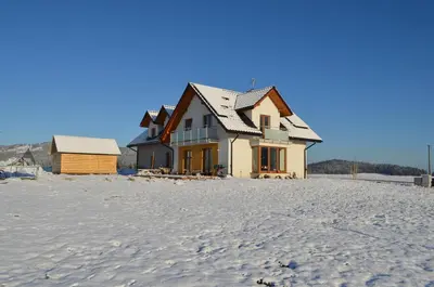 a house on the beach in the snow at Pokoje na Wzgórzu in Kasina Wielka