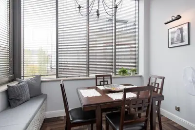 a dining room with a table and chairs and windows at Apartament w centrum Krakowa Ariańska 4 in Kraków