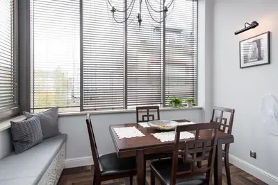 a dining room with a table and chairs and windows at Apartament w centrum Krakowa Ariańska 4 in Kraków