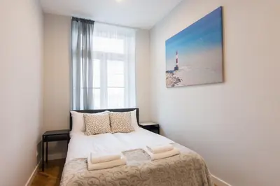 a bedroom with a bed with a window and a lighthouse at Luxury Apartments Nearto Main Square in Kraków