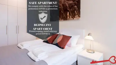 a bedroom with a white bed with a sign on the wall at Luxury Apartments Nearto Main Square in Kraków