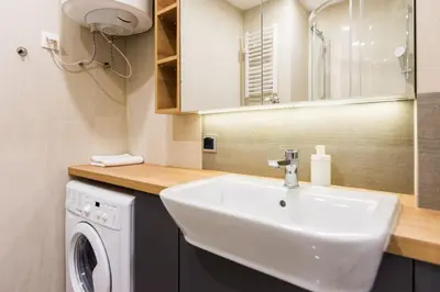 a bathroom with a sink and a washing machine at Luxury Apartments Nearto Main Square in Kraków