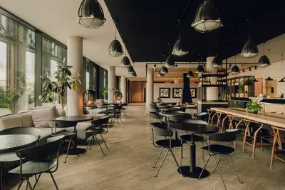a restaurant with tables and chairs and a bar at PURO Kraków Kazimierz in Kraków