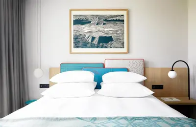 a bedroom with a white bed with a blue headboard at PURO Kraków Kazimierz in Kraków