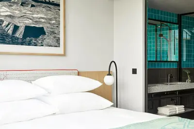 a bedroom with a bed with white pillows and a mirror at PURO Kraków Kazimierz in Kraków