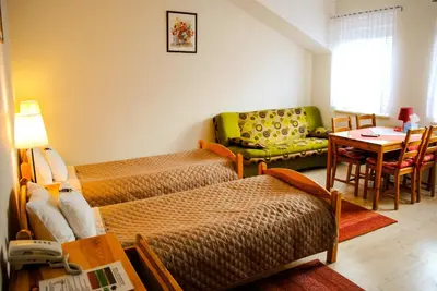 a room with two beds and a table and a couch at Hotel Krak in Myślenice