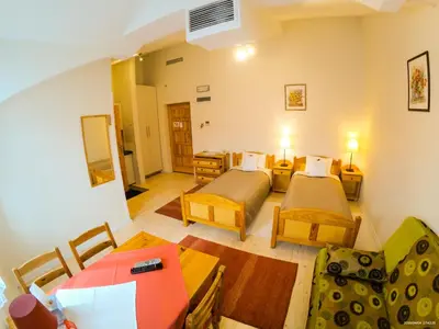a room with two beds and a table and chairs at Hotel Krak in Myślenice