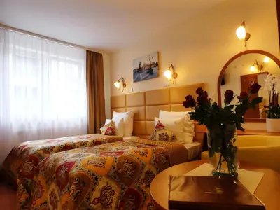 a hotel room with a bed and a vase of flowers at Aparthotel Adler in Kraków