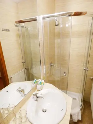 a bathroom with a sink and a shower at Aparthotel Adler in Kraków