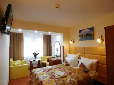 a hotel room with a bed and a chair at Aparthotel Adler in Kraków