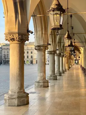 an arcade with columns and lights on a street at BRACKA 15 - Main Square Apartments by MINT APARTMENT in Kraków
