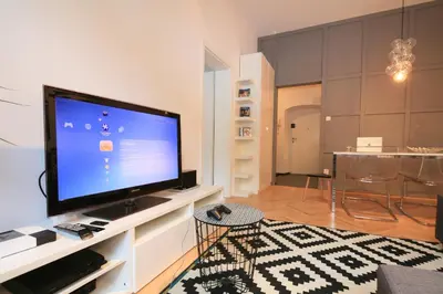 a living room with a large television on a white entertainment center at BRACKA 15 - Main Square Apartments by MINT APARTMENT in Kraków