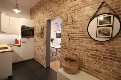 a kitchen with a brick wall and a mirror at BRACKA 15 - Main Square Apartments by MINT APARTMENT in Kraków
