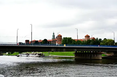 a bridge over a river with a city in the background at The Boat - Hostel&Chill in Kraków