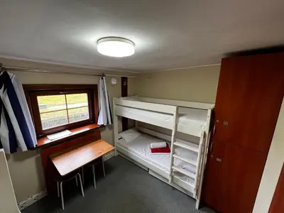 a small room with two bunk beds and a window at The Boat - Hostel&Chill in Kraków
