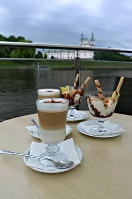 a table with two glasses of coffee and a bowl of food at The Boat - Hostel&Chill in Kraków
