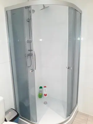 a shower with a glass door in a bathroom at Apartments on Miodowa in Kraków