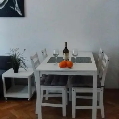 a white table with a bottle of wine and two glasses at Apartments on Miodowa in Kraków