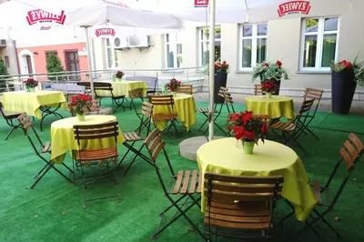 a group of tables and chairs with flowers on them at Hotel-Restauracja Platan in Chrzanów