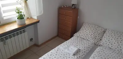 a bedroom with a bed with a pillow and a dresser at Apartament Aga2 in Oświęcim
