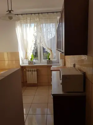 a small kitchen with a window and a microwave at Apartament Aga2 in Oświęcim