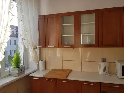 a kitchen with wooden cabinets and a window at Apartament Aga2 in Oświęcim